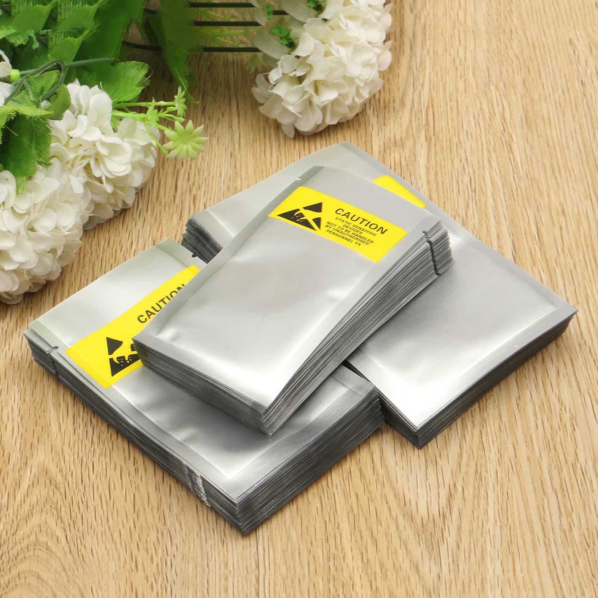 Bolsas ESD metalizadas PREMCO amontonadas con un fondo de madera