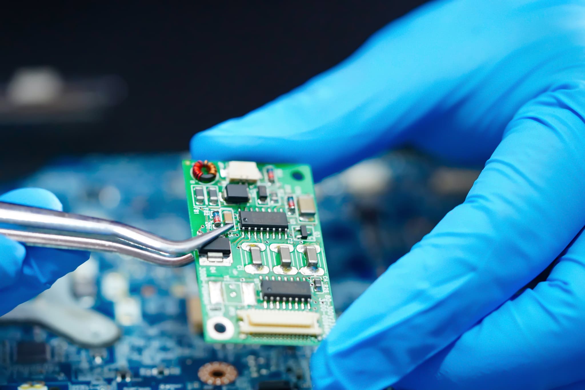 Manos con guantes ESD mientras interactúan con un componente electrónico